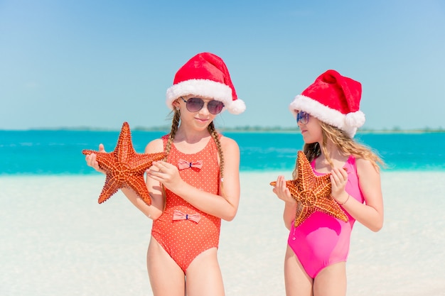 Adorables niñas en vacaciones de Navidad en la playa