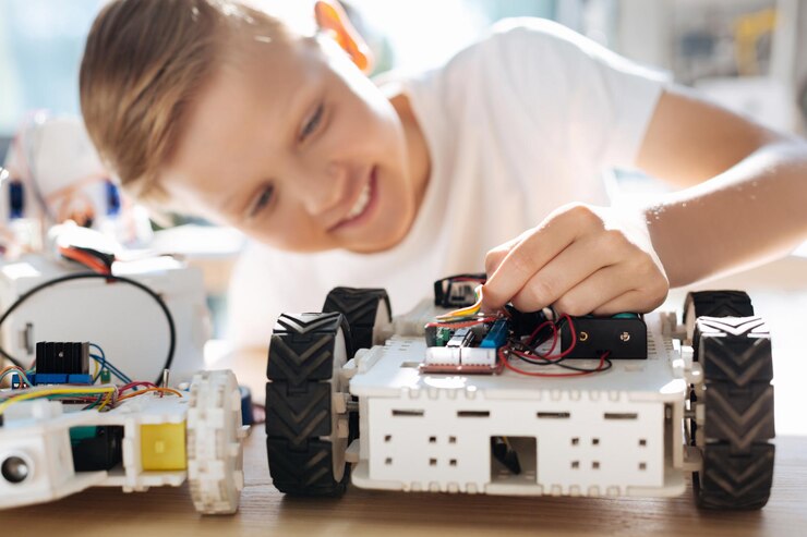 Foto adorables niños preadolescentes inspeccionando el taller de vehículos robóticos