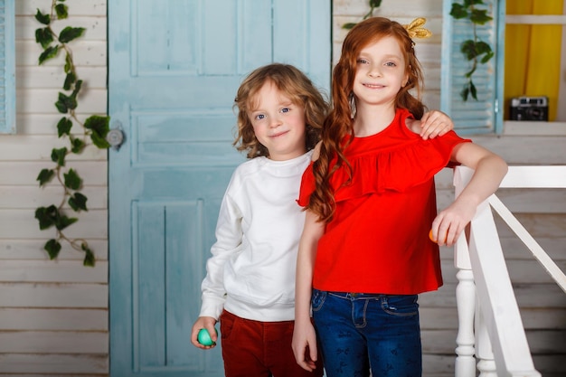 Adoráveis crianças em roupas coloridas, aproveitando as férias. Momentos engraçados. Conceito de férias de primavera. Celebração da Páscoa em família. Menino e menina brincam.