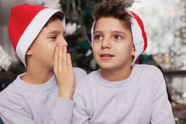 Adoráveis irmãozinhos gêmeos comemorando o Natal em casa