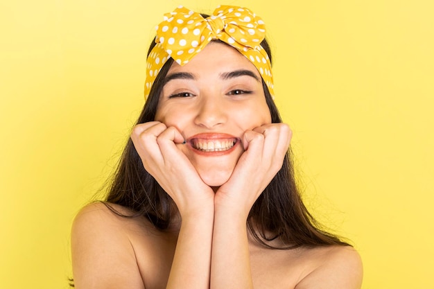 Adoráveis meninas em pé sobre fundo amarelo e sorrindo para a câmera