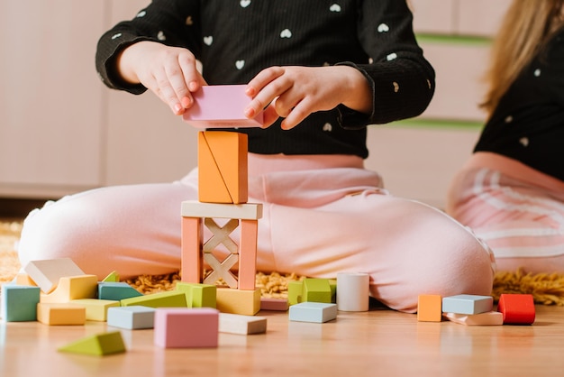 Foto adoráveis meninas estão brincando com blocos coloridos em casa