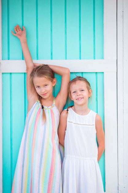 Adoráveis meninas na casa das Caraíbas colorido tradicional do fundo das férias de verão