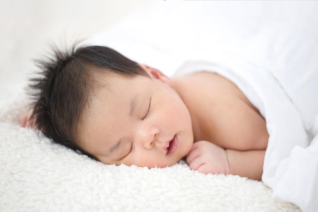 Adorável bebê asiático recém-nascido dormindo em pano peludo