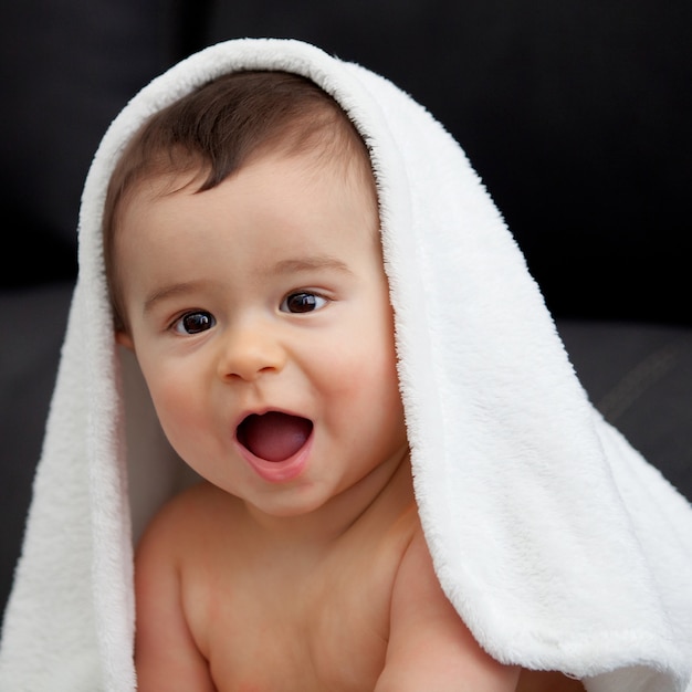 Adorável bebê coberto com uma toalha