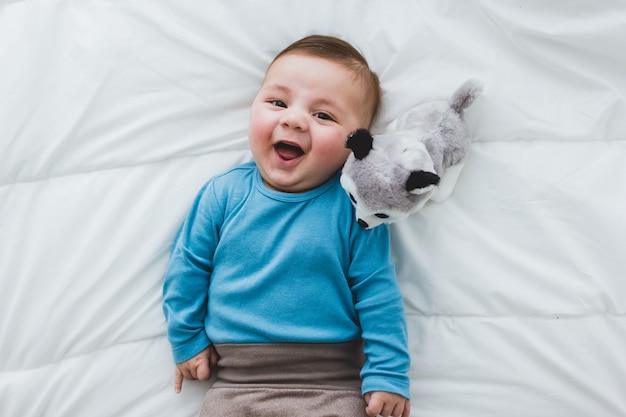 Adorável bebê com um cachorro de brinquedo ao lado