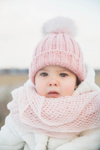 Adorável bebê em um casaco de pele branco