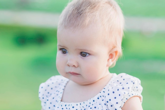 adorável bebê vestido de bolinhas no parque