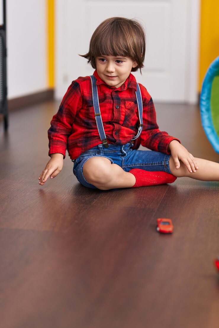 Foto adorável criança brincando com o brinquedo de carros sentado no chão em casa