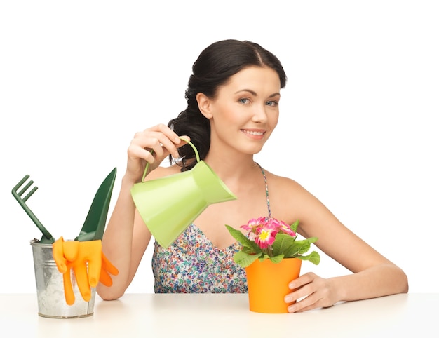 adorável dona de casa com flor em vaso e regador