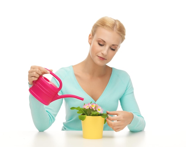 adorável dona de casa com flor em vaso e regador