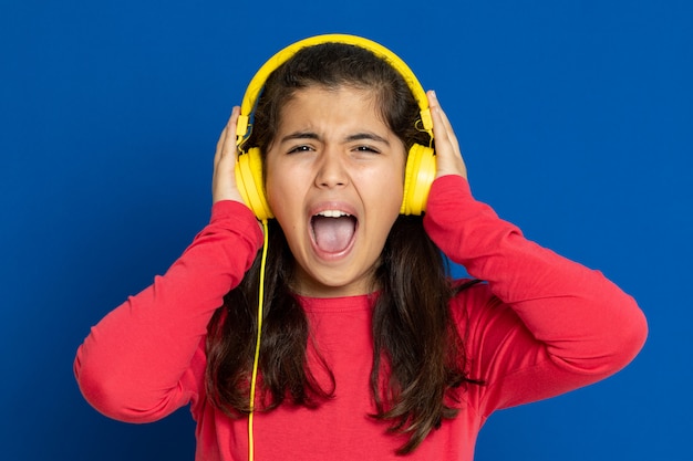 Adorável garota pré-adolescente com camisa vermelha, gesticulando sobre parede azul