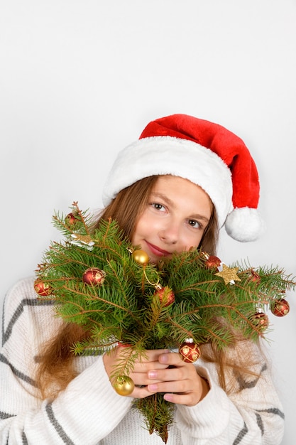 Adorável garota sorridente com chapéu de Papai Noel vermelho