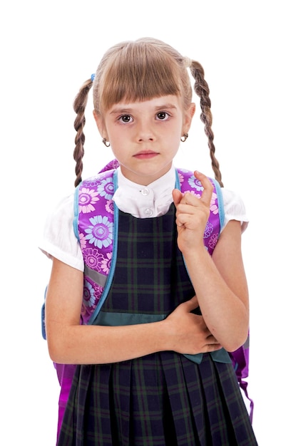 Adorável garotinha com sorriso feliz, mantendo os braços cruzados Garotinha bonita em uniforme escolar Garota bonita com longos cabelos morenos e visual encantador