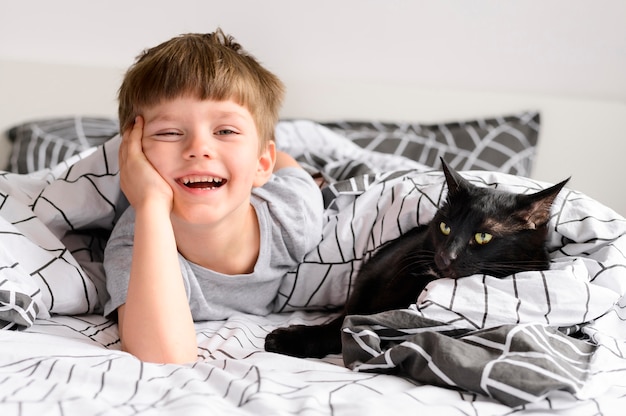 Foto adorável garoto posando com seu gato