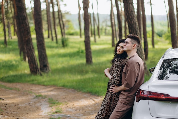 Adorável jovem casal abraçando perto do carro