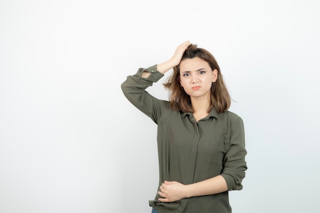 Adorável jovem com roupa casual em pé e pensando. foto de alta qualidade