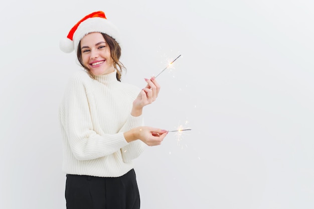 Adorável jovem de suéter branco segura estrelinhas e ri sorri com um sorriso largo