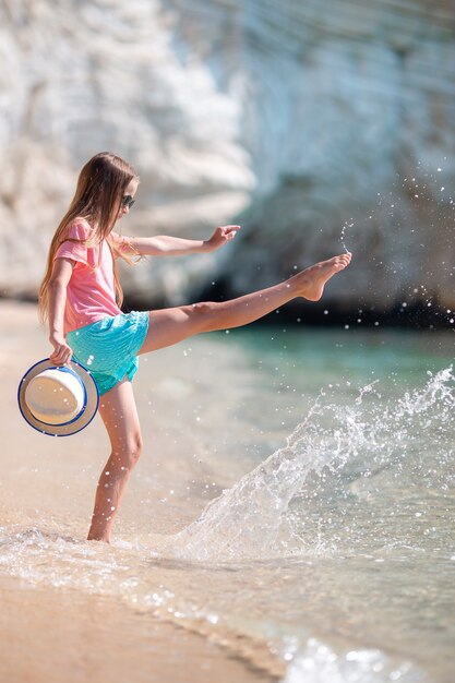 Adorável menina ativa na praia durante as férias de verão