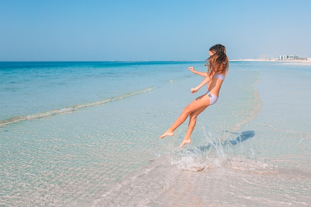 Adorável menina ativa na praia durante as férias de verão