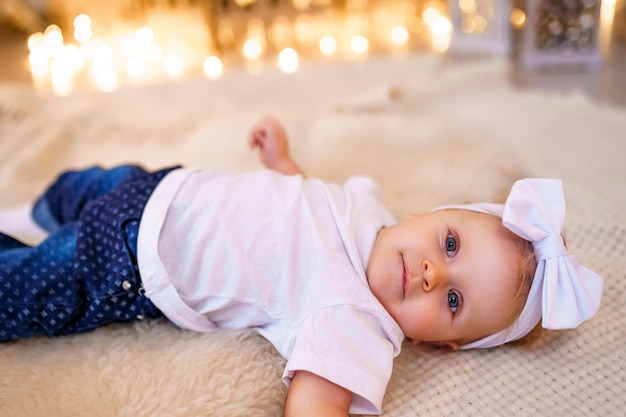 Adorável menina brincando com enfeites sob a árvore de Natal decorada