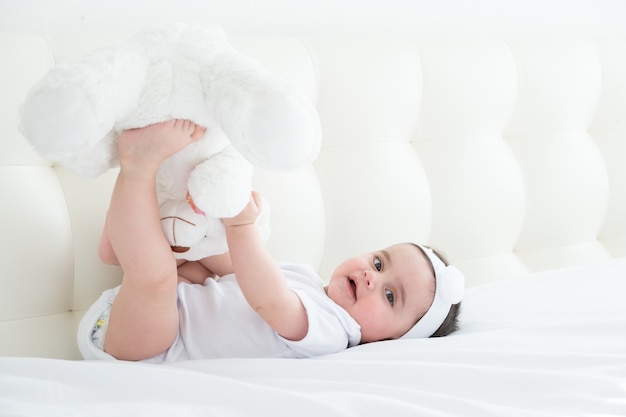 Adorável menina brincando na cama