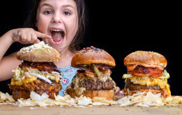 Foto adorável menina com boca aberta e expressão feliz pronta para comer três