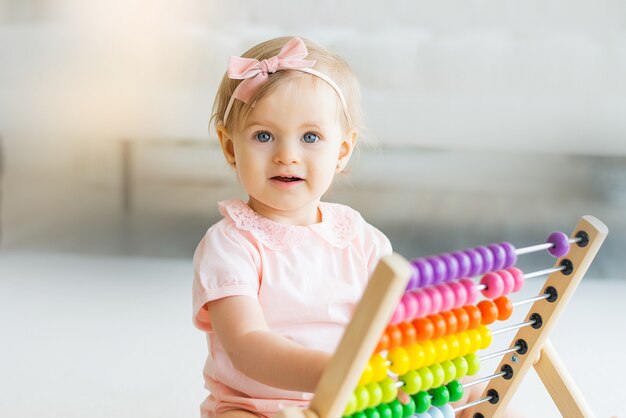 Adorável menina com resultados de brinquedos educativos em casa ou jardim de infância