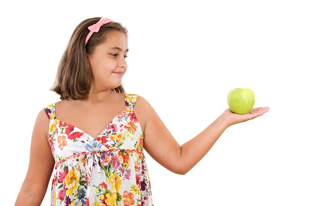 Adorável menina com vestido florido com uma maçã em um fundo branco