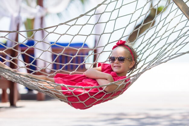 Adorável menina de férias tropicais relaxando na rede