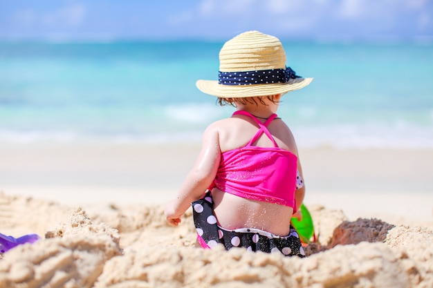 Adorável menina Divirta-se na praia tropical durante as férias