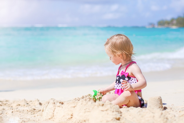 Adorável menina Divirta-se na praia tropical durante as férias