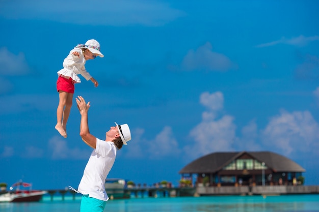 Adorável menina e pai feliz durante as férias de praia tropical