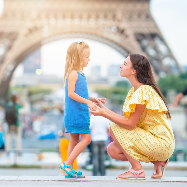 Adorável menina e sua jovem mãe em Paris perto da Torre Eiffel durante as férias de verão