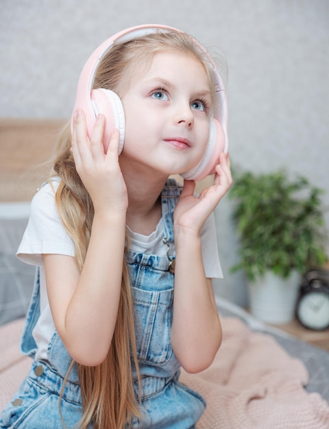 Adorável menina em fones de ouvido se diverte com uma música