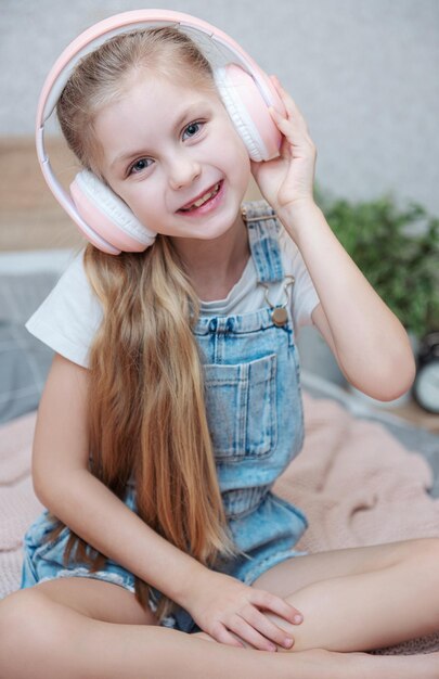 Adorável menina em fones de ouvido se diverte com uma música