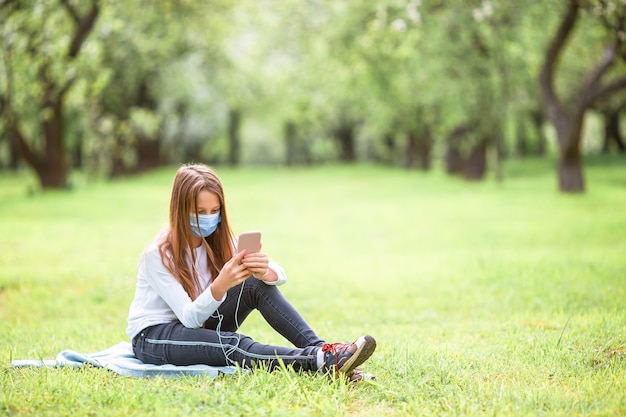 Adorável menina em um jardim de maçãs em flor num lindo dia de primavera