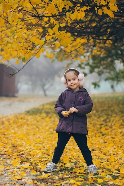 Adorável menina engraçada no parque lindo dia de outono.