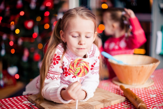 Adorável menina fazendo biscoitos de gengibre de natal