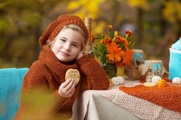 Adorável menina fazendo piquenique no parque de outono