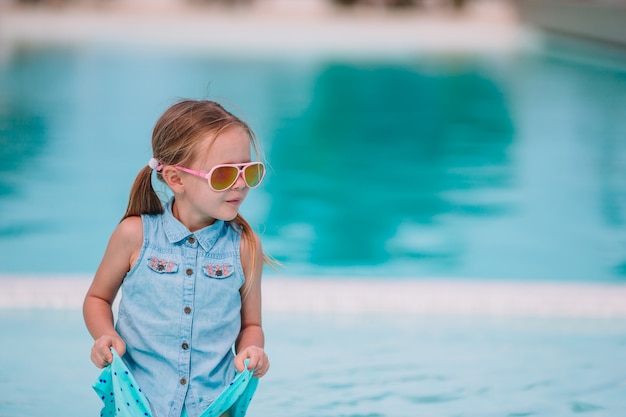 Adorável menina na piscina ao ar livre