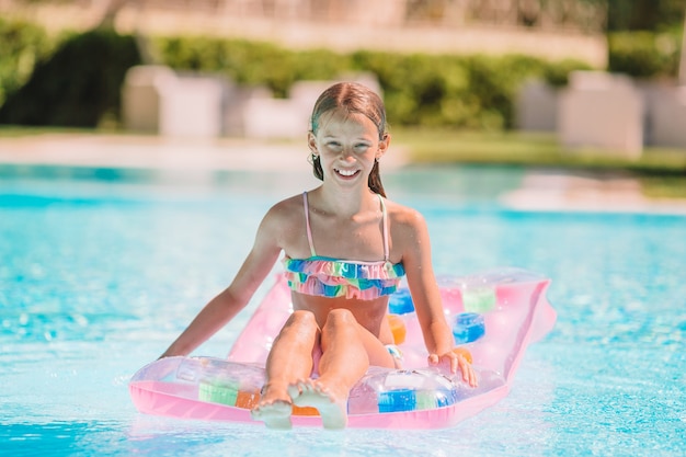 Adorável menina na piscina ao ar livre