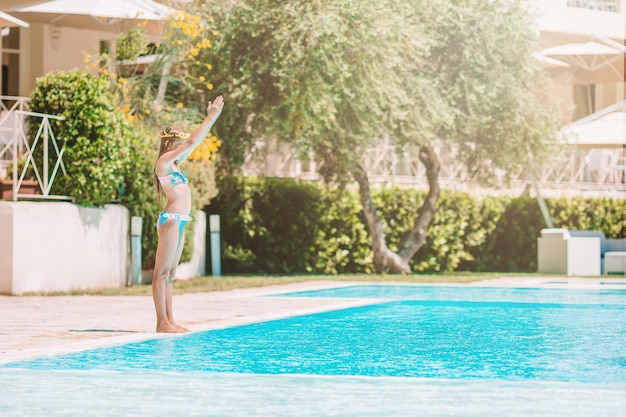 Adorável menina na piscina ao ar livre