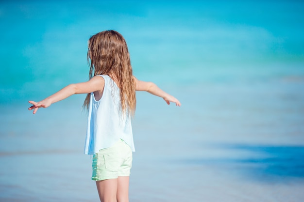 Adorável menina na praia. Garota feliz desfrutar de fundo de férias de verão o céu azul e água azul-turquesa no mar