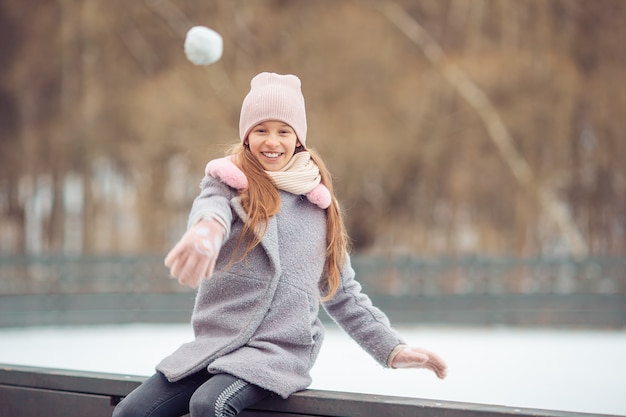 Adorável menina patinando na pista de gelo