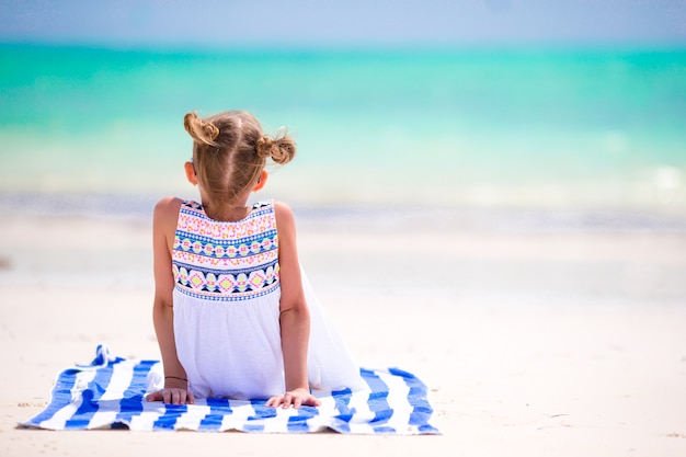 Adorável menina se divertir na praia tropical durante as férias