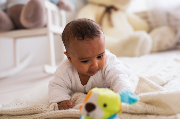 Adorável menino afro-americano brincando com um brinquedo dentro de casa