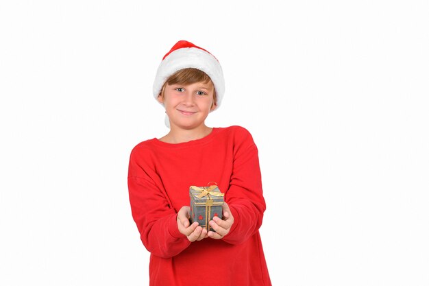 Adorável menino loiro sorridente usando chapéu vermelho de natal ou papai noel e pulôver vermelho esperando por uma nova