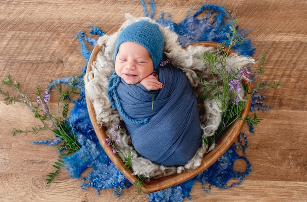 Adorável menino recém-nascido envolto em tecido azul