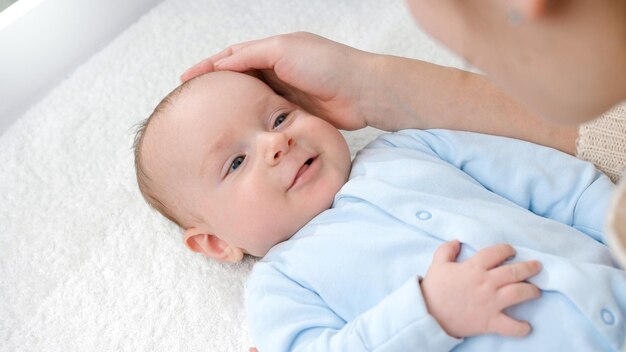 Foto adorável menino sorrindo para a mãe enquanto ela o acaricia na penteadeira conceito de higiene